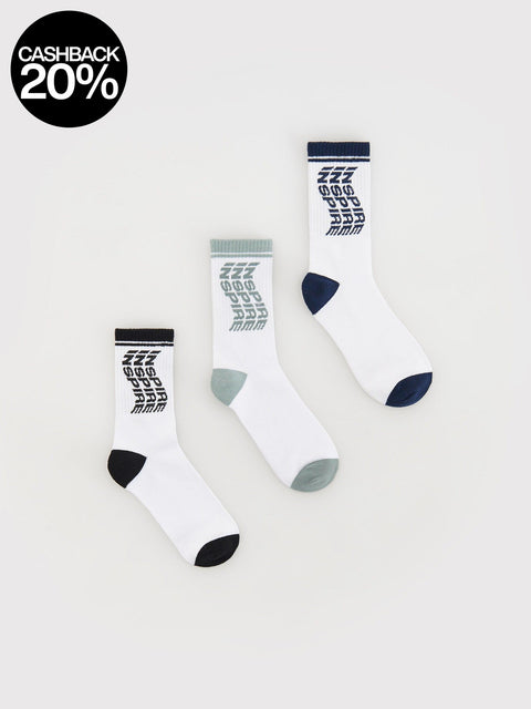 Three white socks with black and gray pattern on a light gray background