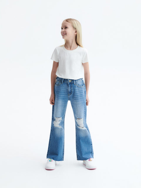 Young girl wearing a white t-shirt and blue jeans with a white background