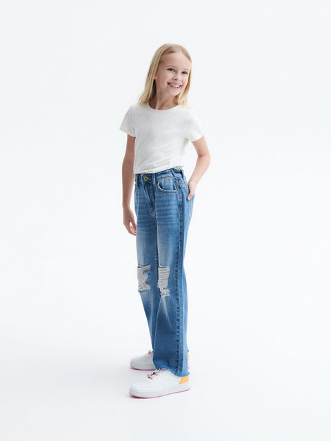 Young girl wearing blue jeans and a white t-shirt on a white background