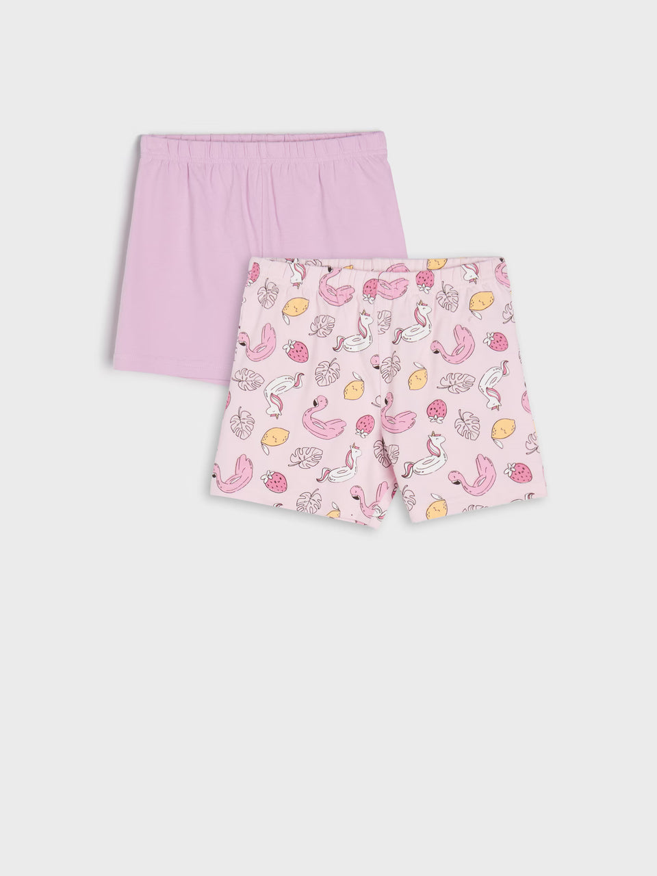 Two pairs of pink shorts on a white background, one plain and one with a fruit pattern.