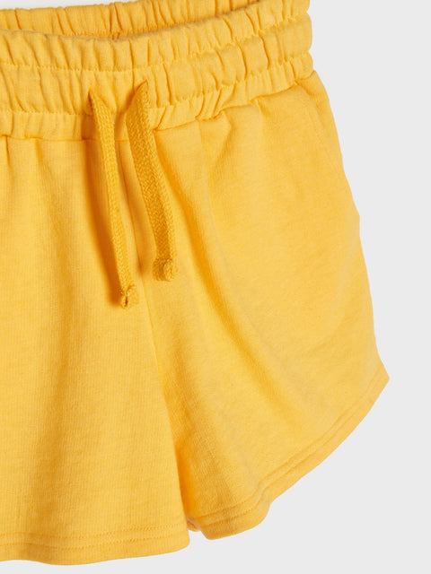 Yellow shorts with an elastic waistband on a light gray background