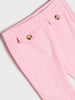 Close-up of pink pants with buttons on a light gray background