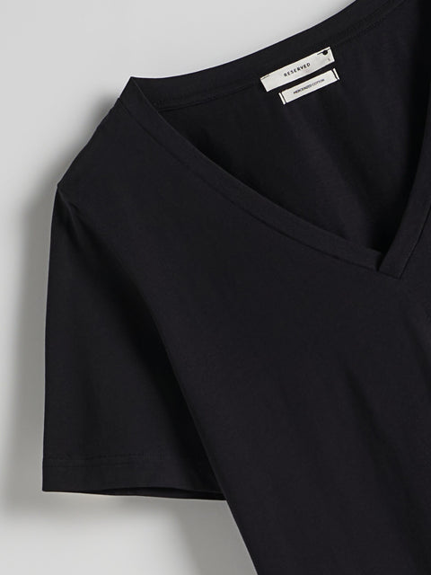 Black top with a brand label on a light gray background