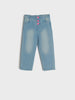 Pair of blue jeans with pink buttons on a white background