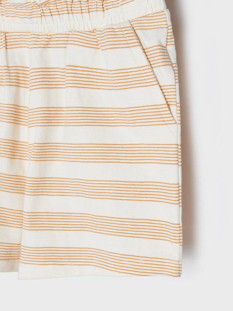 Close-up of a white skirt with thin orange stripes on a white background