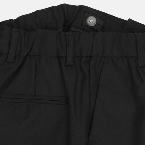 Close-up of black pants with a button on a white background