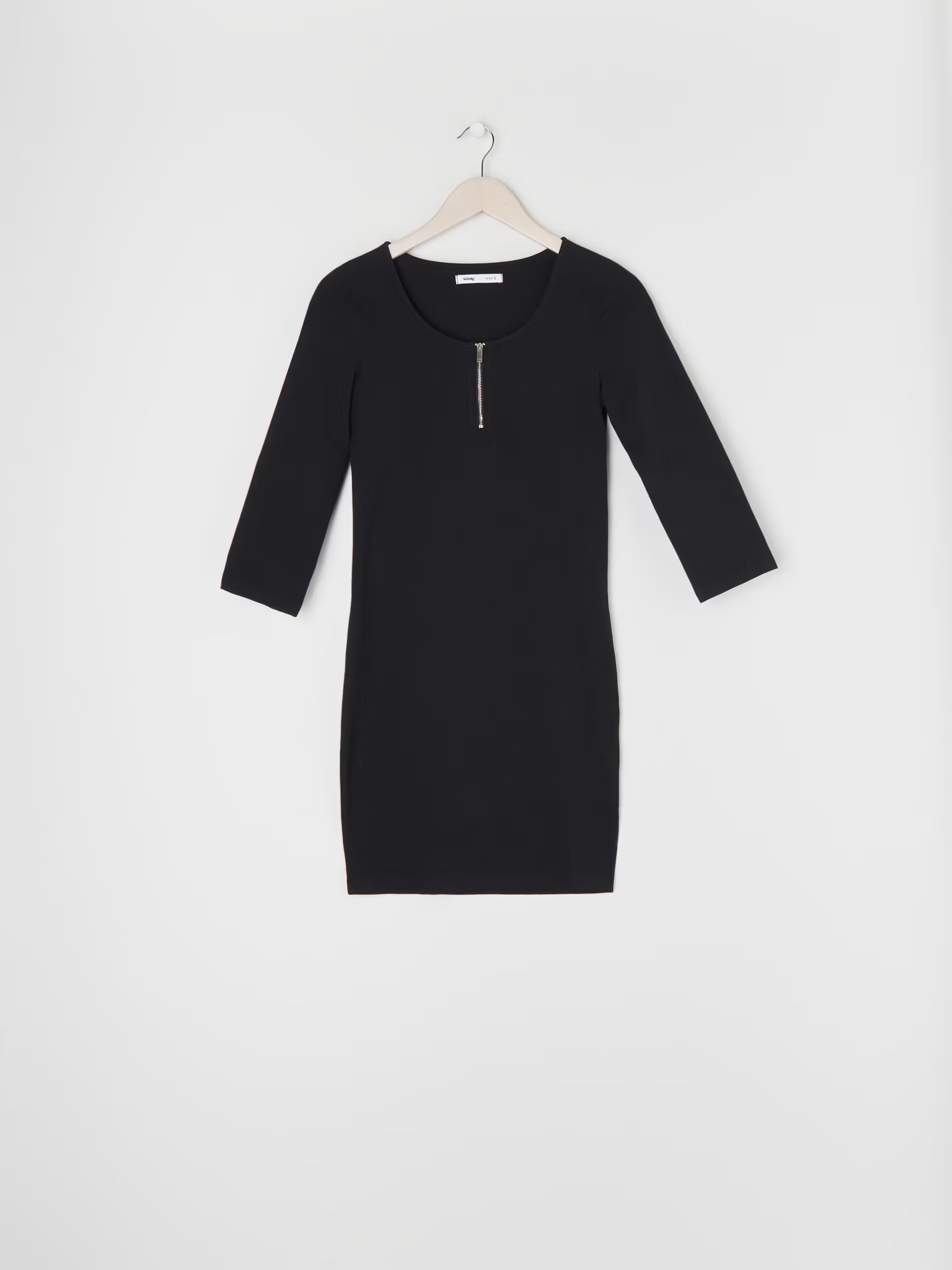 Black dress on a hanger against a white background