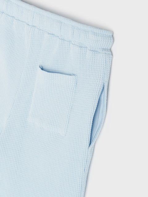Light blue ribbed pants on a white background