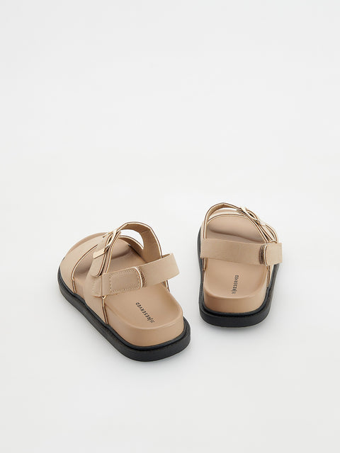 Pair of beige sandals on a light gray background