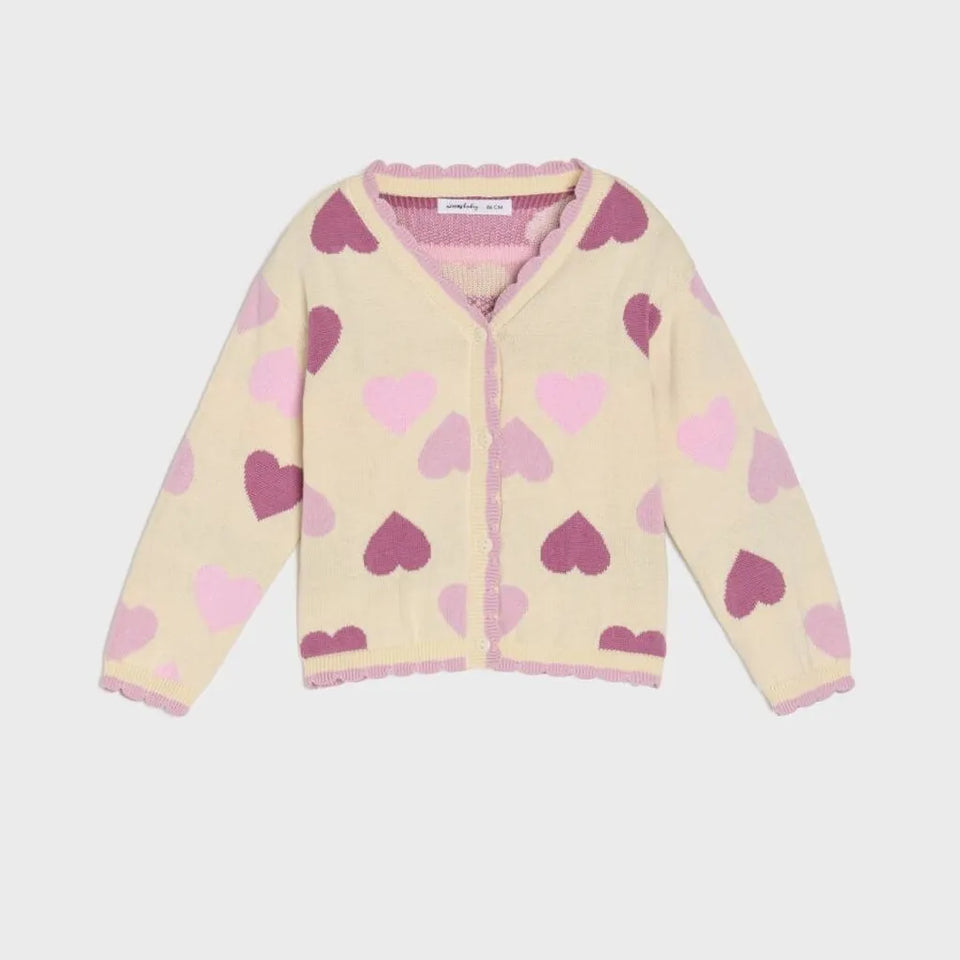 A cream-colored knit cardigan with a pattern of pink and purple hearts, featuring a scalloped pink trim along the neckline, cuffs, and hem.