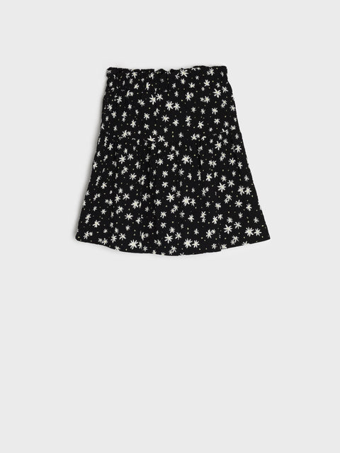 Black skirt with white floral pattern on a light gray background