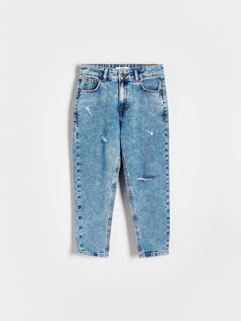 Blue denim jeans with slight distressing on a white background