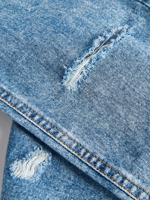 Close-up of blue denim fabric with frayed edges