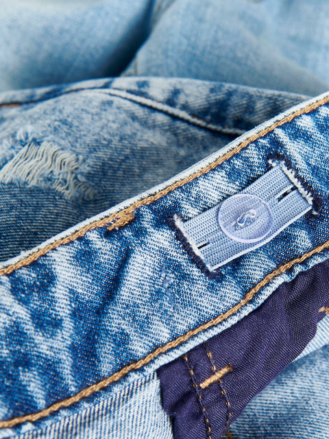 Close-up of a blue denim fabric with a brand label.