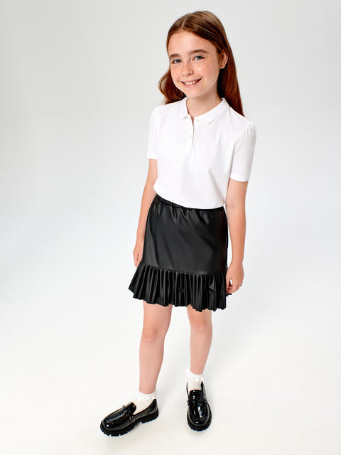 Young girl wearing a white polo shirt and black skirt on a white background