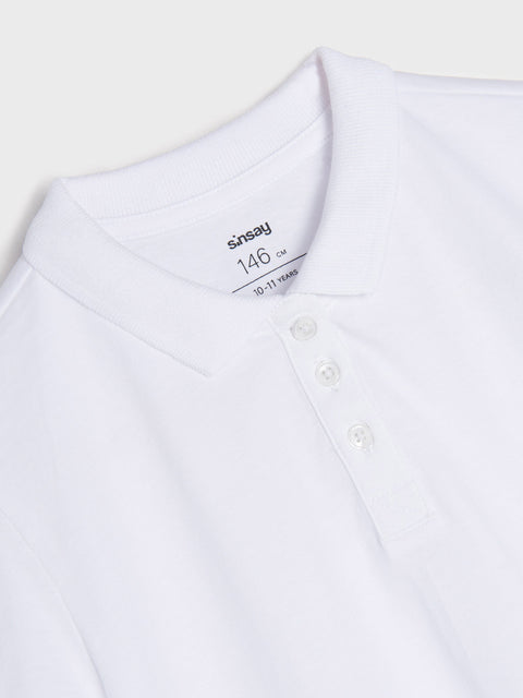 White polo shirt with a brand label on a light gray background