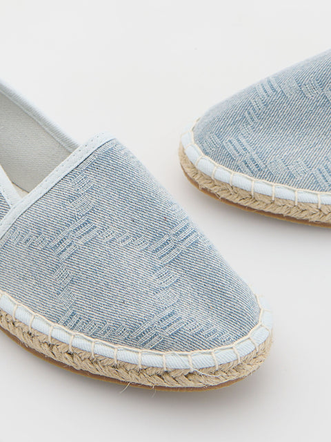 Pair of light blue espadrilles with jute sole on a white background