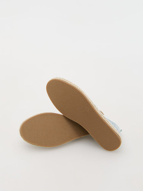 Close-up of brown shoe soles on a light gray background