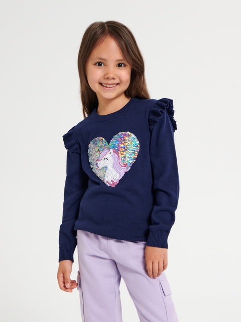 Girl wearing a navy blue sweatshirt with a colorful heart design on a white background
