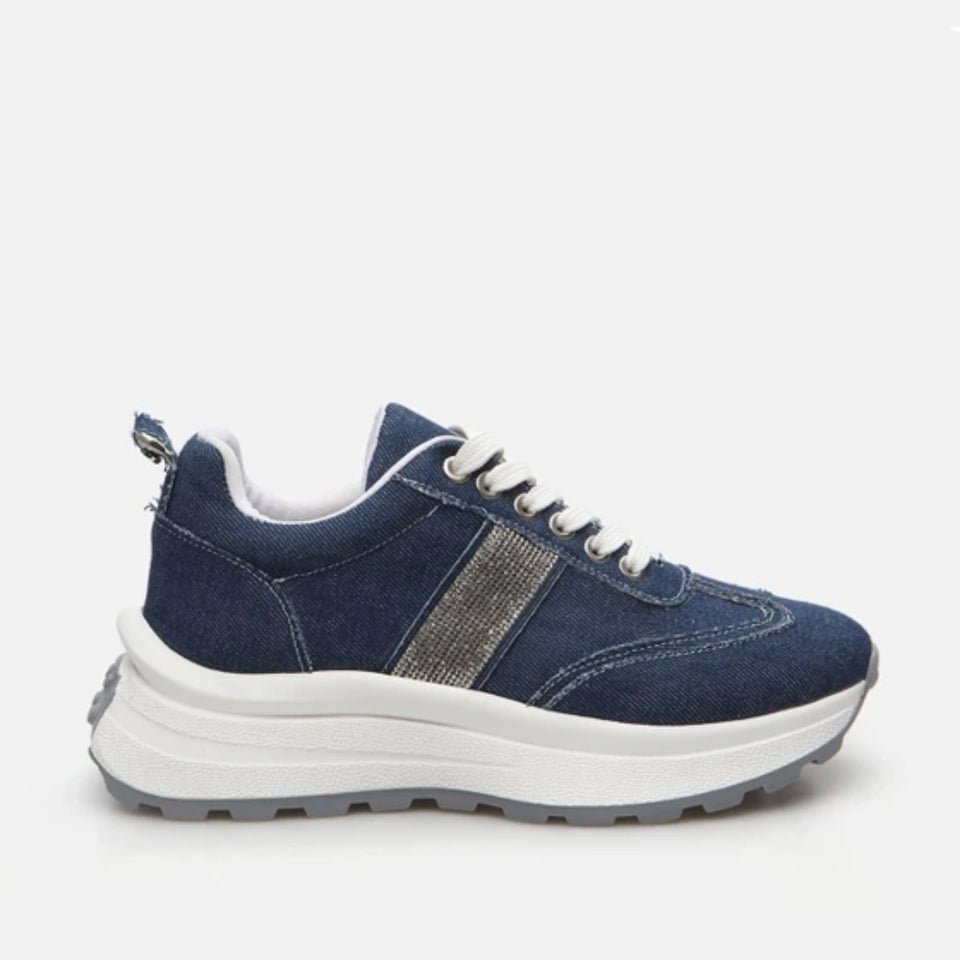 A navy blue low-top sneaker with a textured metallic silver side stripe, white laces, and a chunky white platform sole, shown from a side profile on a light gray background.