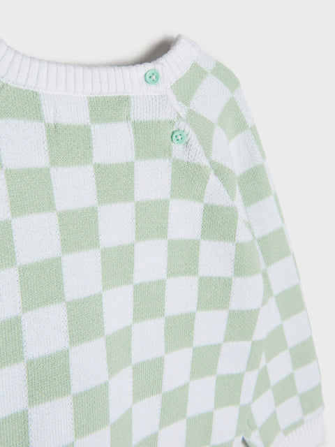 Green and white checkered sweater on a light gray background