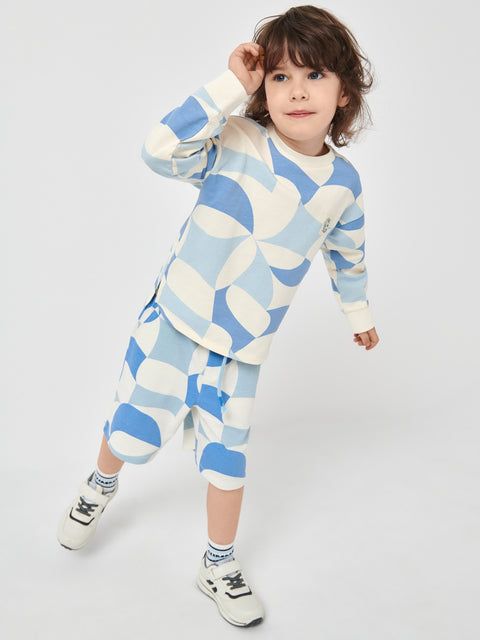 Child wearing a blue and white patterned outfit on a plain background