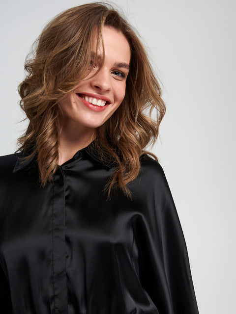 Woman wearing a black shirt against a plain background