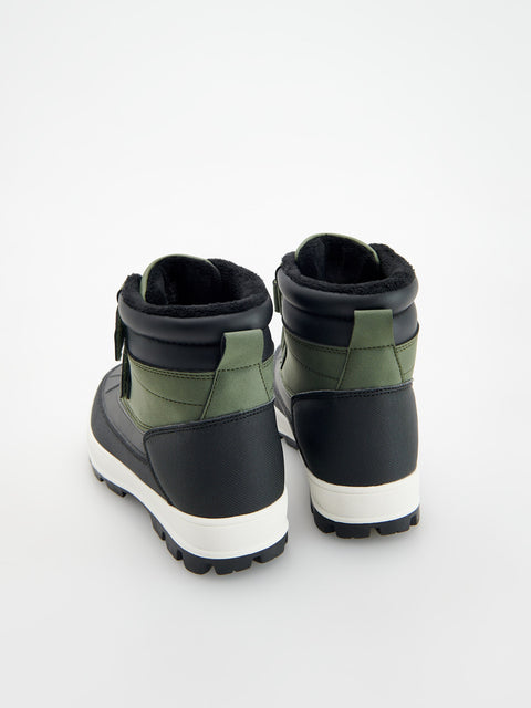 Pair of black and green winter boots on a white background