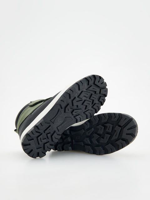 Close-up of a pair of green hiking boots with black soles on a white background