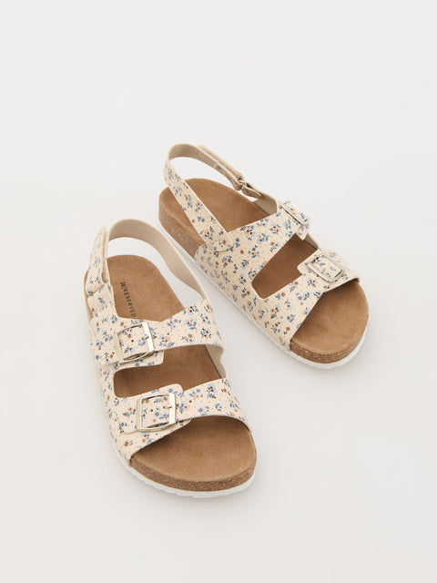 Pair of floral sandals on a light gray background