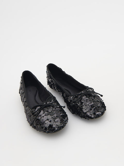 Black sequined flats on a white background
