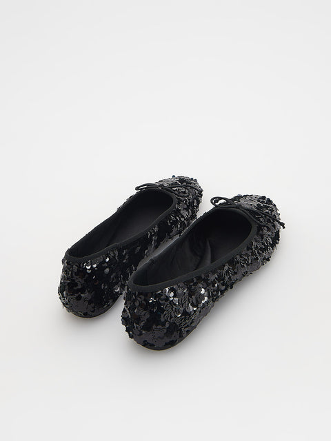 Pair of black sequin shoes on a white background