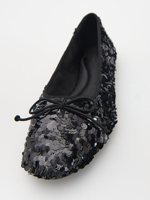 Black sequin flat shoe on a white background