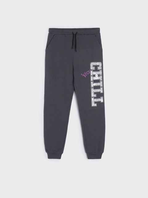 Black sweatpants with 'CHILL' text on a white background