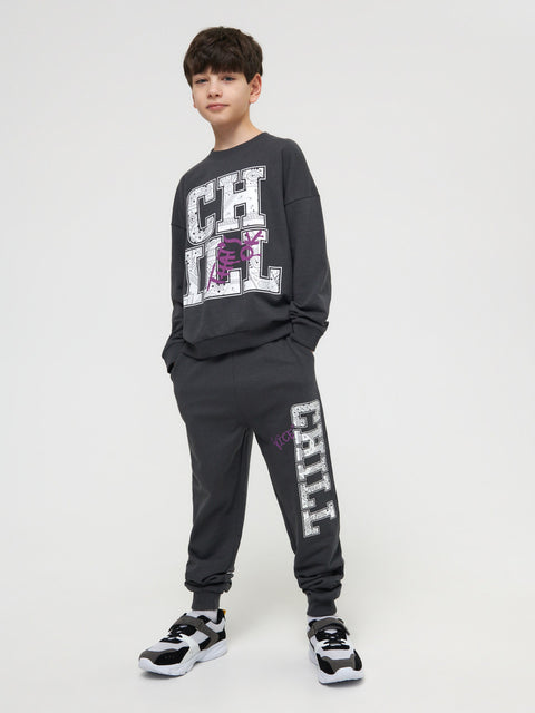 Person wearing a dark gray sweatshirt and pants with 'CHILL' text on a white background