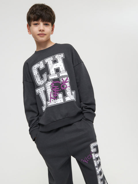 Child wearing a black sweatshirt with 'CH' design on a white background