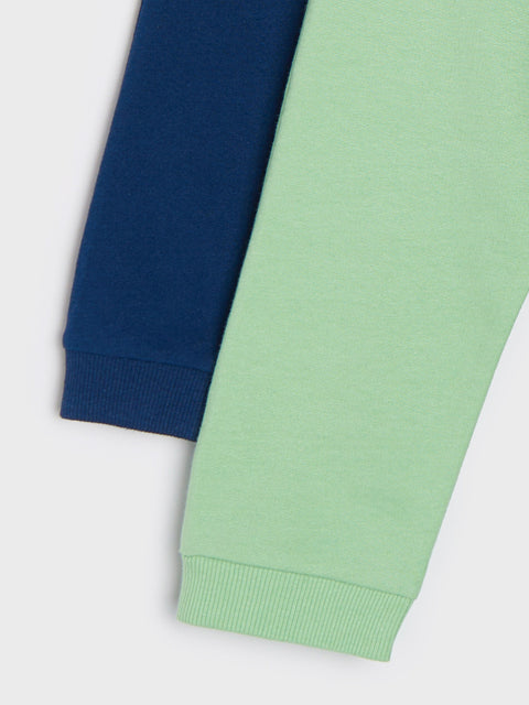 Close-up of navy and green sweatpants on a white background
