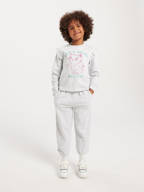Child wearing a light gray sweatshirt and pants with a graphic design on a white background