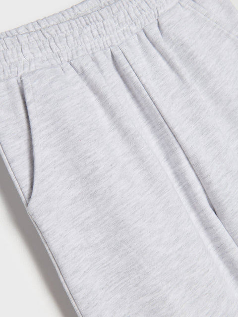 Close-up of light gray sweatpants on a white background
