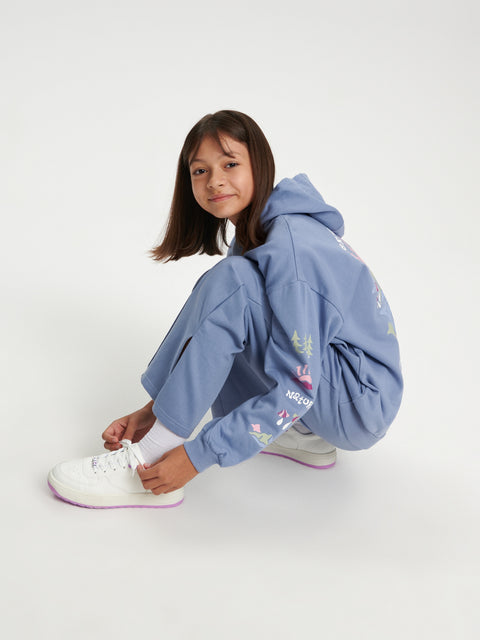 Child wearing a blue tracksuit with colorful designs on a white background