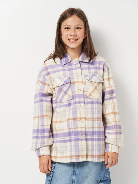 Person wearing a plaid shirt with purple and white pattern on a plain background