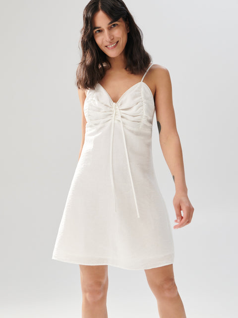 Woman wearing a white dress on a plain background