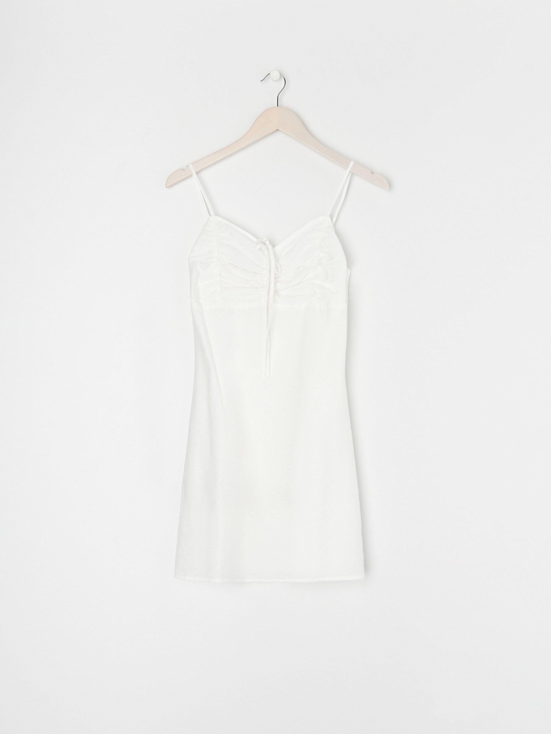 White dress on a hanger against a white background