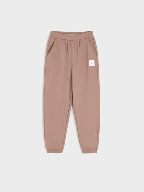 Brown sweatpants with a small white logo on a light gray background