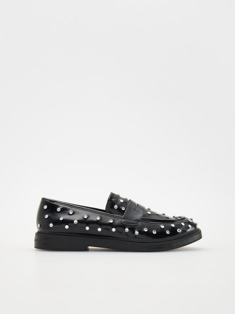Black loafers with studded details on a white background