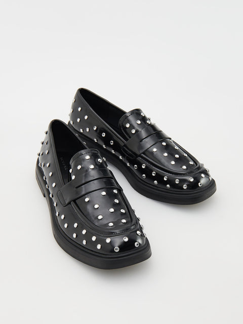 Black loafers with silver studs on a white background