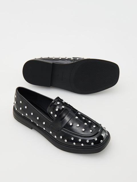 Black loafers with silver studs on a white background