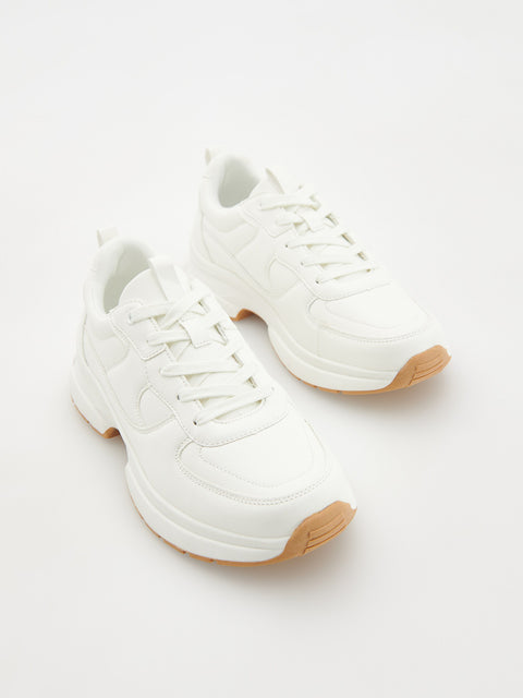White sneakers with brown soles on a white background
