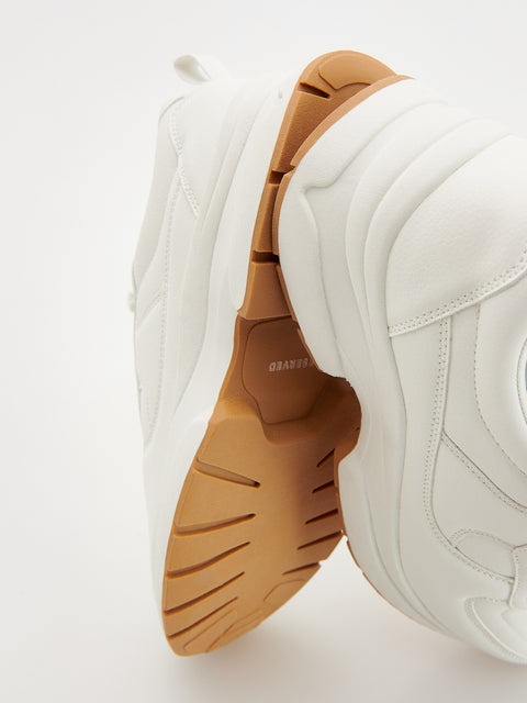 White sneakers with brown soles on a light gray background
