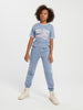 Person wearing a blue 'North Dakota' t-shirt and pants on a white background